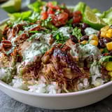 Savory slow-cooked carnitas burrito bowl bursting with colorful, fresh Mexican-inspired ingredients.