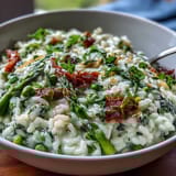 Spring Dinner Party Pea and Mint Risotto with Parmesan, a vibrant creamy dish bursting with fresh peas and fragrant mint, served in a rustic bowl.
