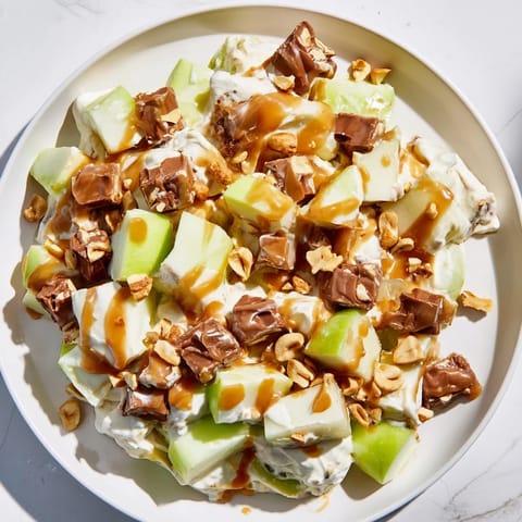 Creamy Snickers Salad, a delightful mix of apples, candy, and whipped topping, ready to serve!
