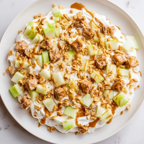 This tempting Snickers Salad features chopped Snickers and Granny Smith apples in a sweet, cool treat.