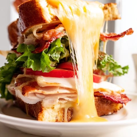 Toasted sourdough holds roasted turkey, crispy bacon, and fresh veggies in this hearty Turkey Club Grilled Cheese.