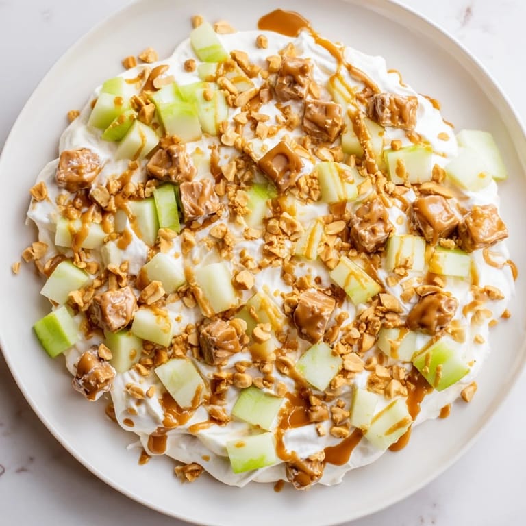 This tempting Snickers Salad features chopped Snickers and Granny Smith apples in a sweet, cool treat.