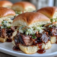 1. Smoky BBQ brisket sliders with tangy sauce and crisp slaw on soft buns, perfect for parties and gatherings.  