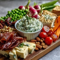 Spring charcuterie board with radishes, peas, and herb dip features vibrant veggies, savory meats, and creamy dip for easy entertaining.